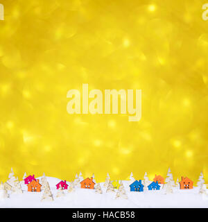 Weihnachten-Bokeh-Hintergrund mit kleinen Holzhäusern, Weihnachtsbäume und Schnee Stockfoto