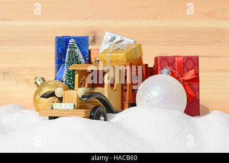 Weihnachten Hintergrund. Spielzeug-LKW mit Geschenken, Neujahr Tanne und Kugeln im Schnee Stockfoto