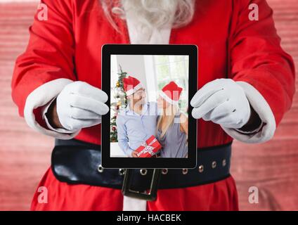 Hält eine digitale-Tablette mit Foto des Paares Weihnachten Weihnachtsmann Stockfoto