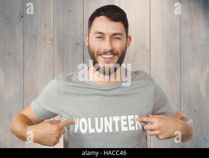 Lächelnder Mann zeigte auf freiwillige Titel auf seinem t-Shirt Stockfoto