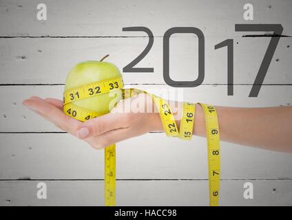 Hand halten grünen Apfel umhüllt mit Maßband gegen 2017 Stockfoto