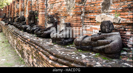 Detail der vielen kopflose Buddhas entlang einer Wand an der Tempel Wat Mahathat, Tempel der Großen Relikt, in Ayutthaya, Thailand Stockfoto