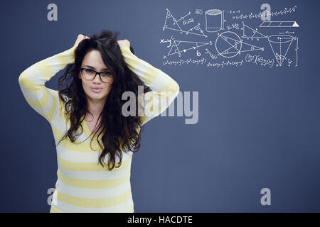 Junge begeistert Frau auf blau grauen Hintergrund mit Mathematik Graphen. Stockfoto