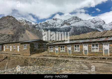 Großer Höhe Touristen Lodge auf dem Annapurna Circuit Trek mit schneebedeckten Bergen im Hintergrund im Himalaya, Nepal Stockfoto