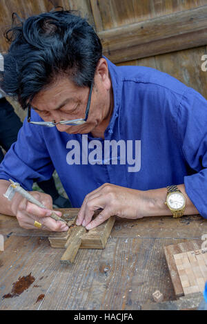 Ein Meister in der Kunst der chinesischen Movable Type Druck ausgebildet schnitzt aus Holz Zeichen Dongyuan Village, Ruian, China. Stockfoto
