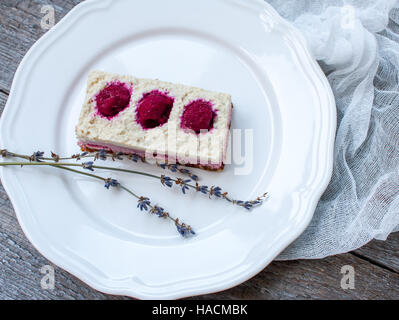 Rohe Cashew-Kuchen (Käsekuchen) und Beeren (Erdbeeren, Kirschen), Lavendel auf einem hölzernen Hintergrund. . Perfekt für die Detox-Diät oder einfach eine gesunde des Stockfoto