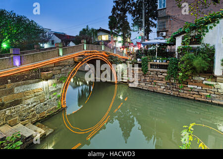 Historische Altstadt in chinesischen Stadt Suzhou mit mehreren Kanälen und Brücken, bekannt als "chinesische Venedig" bei Sonnenuntergang mit Neon Lichter Beleuchtung. Stockfoto