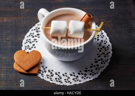 Tasse heißen Kakao Getränk mit Süßigkeiten auf dunklen Holztisch Stockfoto