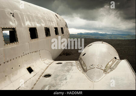 Island - Solheimasandur United States Navy Flugzeug Wrack mit Blick auf die Berge und schweren Sturm Wolken im Hintergrund Stockfoto