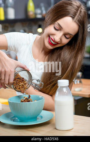 Frau mit Müsli-Frühstück in der Küche Stockfoto