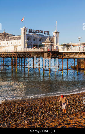 England, East Sussex, Brighton, Mann mit Metalldetektor am Strand und Pier von Brighton Stockfoto