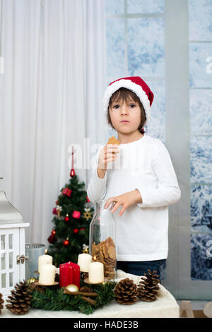 Weihnachten-Porträt von niedlich kleine Vorschule junge, Kekse und spielen mit Schneemann an einem Wintertag im Innenbereich Stockfoto