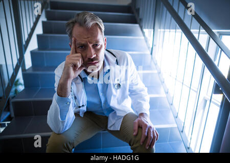 Porträt von traurig Arzt sitzt auf der Treppe Stockfoto