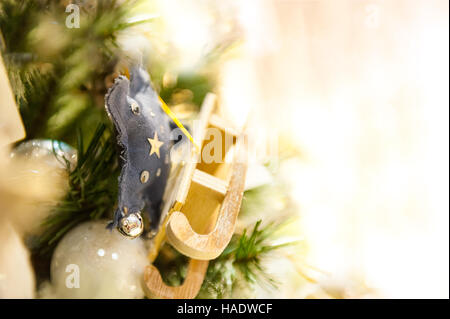 Weihnachten Spielzeug alte Holzschlitten hängen Zweig brennende Kerzen, Boxen, Kugeln, Pinienzapfen, Walnüsse, Branchesin Hintergrund andere Dekorationen und Girlanden. Textfreiraum. Stockfoto