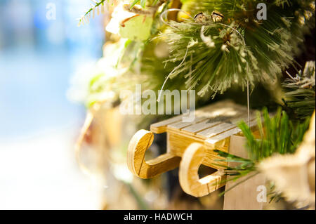 Weihnachten Spielzeug alte Holzschlitten hängen Zweig brennende Kerzen, Boxen, Kugeln, Pinienzapfen, Walnüsse, Branchesin Hintergrund andere Dekorationen und Girlanden. Textfreiraum. Stockfoto