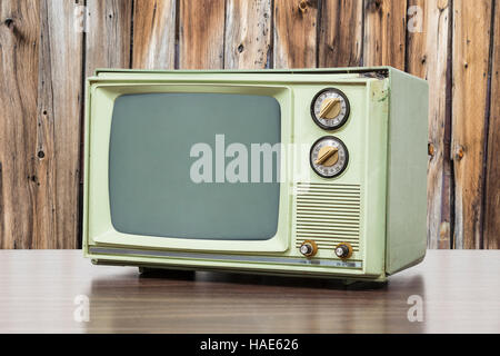 Grün Vintage Fernsehen mit alten Holz Wand. Stockfoto