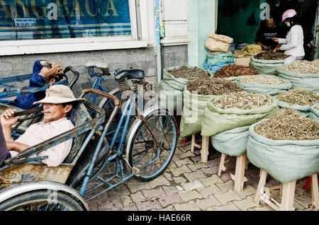 Cyclo-Taxifahrer und Kräuterladen in Saigon-Ho-Chi-Minh-Stadt-Straße in vietnam Stockfoto