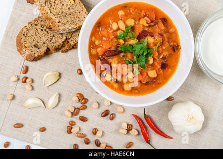Chili-Bohnen-Eintopf, Brot, Chili-Paprika und Knoblauch bereit um bedient zu werden Stockfoto
