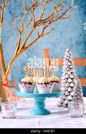 Glückliches neues Jahr 2017 Cupcakes auf einer modernen, stilvollen, festliche, blaue Gold und weiße Winter Thema Tabelle festlegen, vertikale. Stockfoto