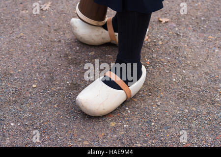 Frau-Beine mit ein paar ziemlich neue Holzschuhe mit Lederriemen Stockfoto