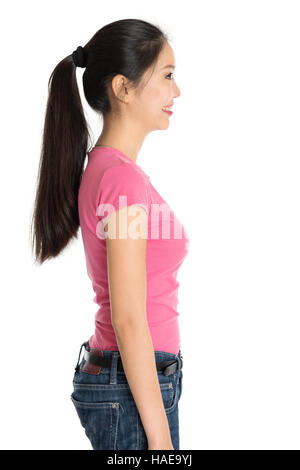 Profil anzeigen von jungen asiatischen Mädchen in rosa Hemd und Jeans mit Pferdeschwanz Haare, stehen isoliert auf weißem Hintergrund. Stockfoto