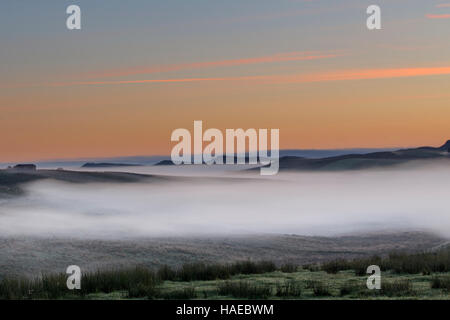 Schön tief liegenden Nebel im Morgengrauen unter Peel Felsen und Highshield Felsen, Blick nach Osten von Stahl Rigg, Hadrianswall Stockfoto