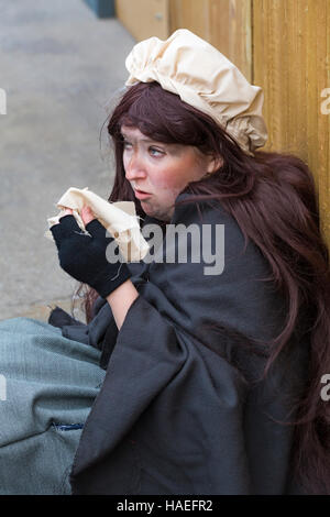 Das arme Mädchen auf der Straße mit Taschentuch im Victorian Weihnachtsfest in Portsmouth, Hampshire, England Großbritannien im November Stockfoto