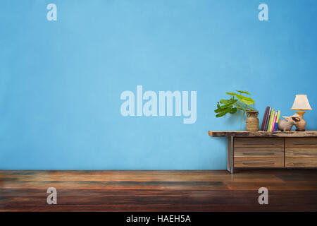 grüne Pflanzen Keramik Vase auf Schublade aus Holz in leere blaue Vintage Wohnzimmer Interieur Stockfoto