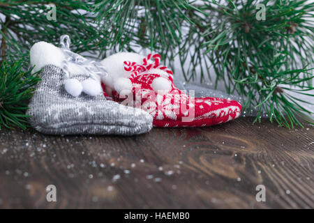 Weihnachten-Zusammensetzung von zwei gestrickte Socken und Weihnachtsbaum Äste auf hölzernen Hintergrund Stockfoto