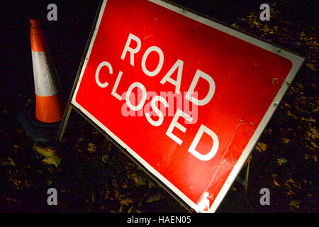 Straße gesperrt Schild mit einem 750mm Verkehr Kegel im Dunkeln im Herbst Stockfoto