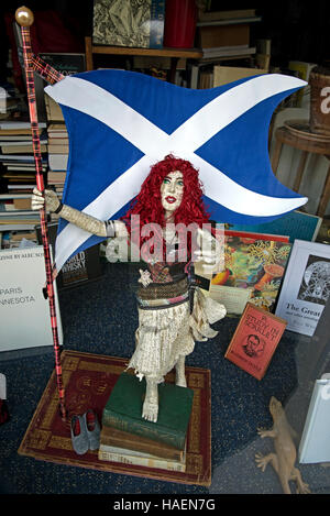 Eine Figur aus alten Büchern zeigt eine rothaarige Frau hält die Saltire im Fenster ein Antiquariat in Edinburgh. Stockfoto