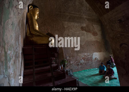 Menschen beten vor einer goldenen Buddha-Statue im Sulamani Tempel in Bagan, Myanmar. Stockfoto