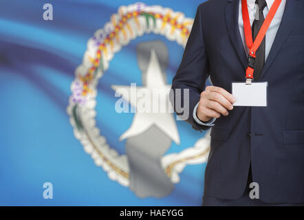 Geschäftsmann hält Namensschild Karte auf ein Schlüsselband mit einer Flagge auf Hintergrund - Nördliche Marianen Stockfoto