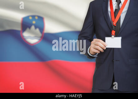 Geschäftsmann, ein Schlüsselband mit einer Flagge auf Hintergrund - Slowenien Karte Namensschild festhalten Stockfoto