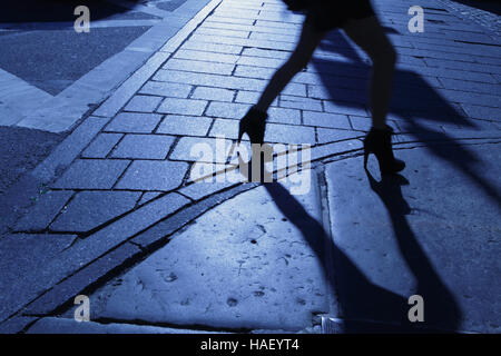 Blaue Nacht Schatten und Silhouette einer Frau zu Fuß hinunter einen New Yorker Bürgersteig Stockfoto