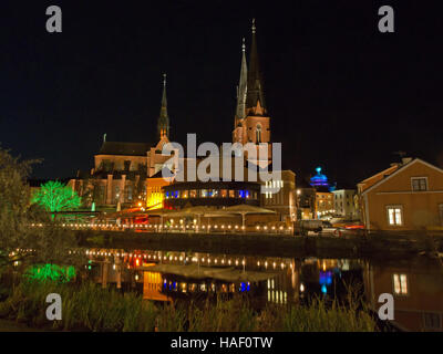 Einen malerischen Blick auf die Westseite des Fyris River bei Nacht mit Uppsala Kathedrale hinter eine Markthalle mit Restaurants Schweden Stockfoto