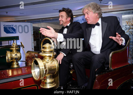 Die Moderatoren der Fernsehserie The Grand Tour, Richard Hammond und James May posieren in einem frühen Automobil von 1900 Simms, nachdem sie eine Rede beim 100. Jährlichen Abendessen der Society of Motor Manufacturers and Traders im Grosvenor House in London gehalten haben. Stockfoto