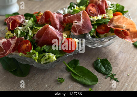 grüner Salat mit Schinken auf einem Küchentisch Stockfoto