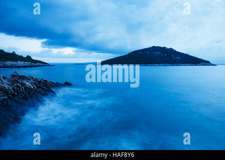 Wellen, die wie ein Sturm bewegt sich Weg über Veli Osir und Mali Osir Inseln in der Morgendämmerung, gesehen vom Zaosiri Strand, Cunski auf Insel Losinj, Kroatien. Stockfoto