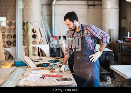 Tischler arbeiten, sorgfältiger Blick auf die Pläne Stockfoto