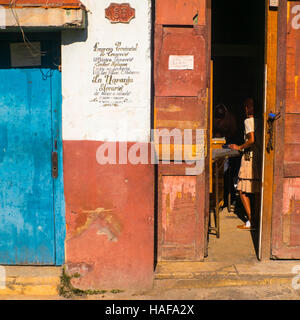 Shop Eingang Havanna Kuba West Indies Frauengestalt steht am offenen Tür halb im Schatten Stockfoto