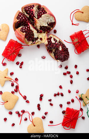 Rahmen der hausgemachte Christmas Cookies, Granatapfelkernen und Geschenke mit Kopie Spase für Urlaub Text. Xmas handgemachte Dekoration auf weißen Tisch betrachtet aus Stockfoto