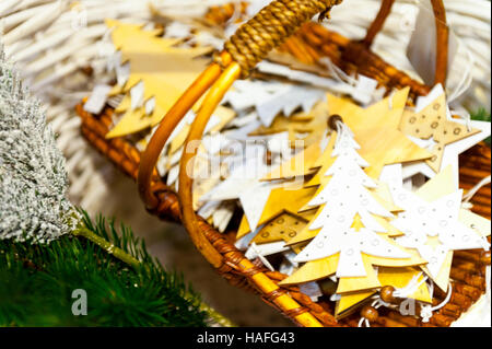 Weihnachten Tannenbaum und Sterne alte Spielzeuge aus Holz im Korb brennende Kerzen, Boxen, Kugeln, Pinienzapfen, Walnüsse, Branchesin Hintergrund andere Dekorationen-Girlanden. Textfreiraum. Stockfoto