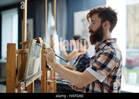 Seitenansicht des bärtigen Mann malen im Atelier Stockfoto