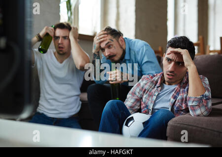 Unzufrieden Jungs sitzen vor Fernseher und Fussball übertragen Stockfoto