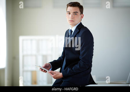 Schwere jungen Führer mit Touchpad Blick in die Kamera Stockfoto