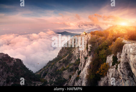 Panorama Berglandschaft bei Sonnenuntergang. Aussicht vom Gipfel auf den hohen Felsen, Himmel, Wolken und Bäume am Abend Stockfoto