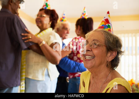Gruppe von alten Freunden und Familie feiern senior Geburtstagsfeier im Altenheim. Patienten im Hospiz lächelnde Frau. Stockfoto