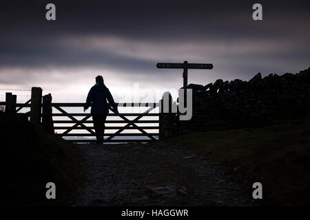 Eine Walker Silhouette gegen Himmel kommt an einem Tor, dass Schüler/inen Flintshire und Denbighshire im Bereich Clwydian, Nordwales. Stockfoto