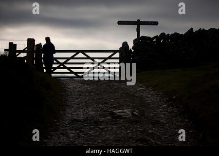 Eine Walker Silhouette gegen Himmel kommt an einem Tor, dass Schüler/inen Flintshire und Denbighshire im Bereich Clwydian, Nordwales. Stockfoto